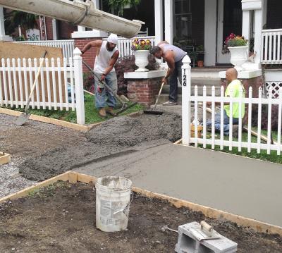 Workers pouring concrete for new residential sidewalk